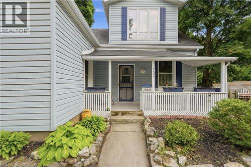 Light blue vinyl siding exterior with a covered front porch featuring white railings - 153 Montrose Street N, Cambridge, ON - Outdoor With Deck Patio Veranda With Exterior