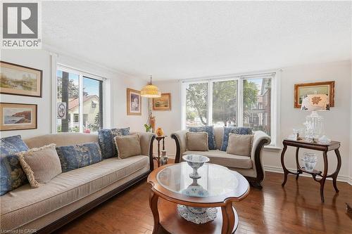 Bright living area featuring wood-finish flooring, white walls, and a large bay window - 153 Montrose Street N, Cambridge, ON - Indoor Photo Showing Living Room