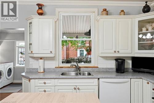 Kitchen featuring off-white cabinetry, a double basin stainless steel sink, a light gray countertop, and a white subway tile backsplash - 153 Montrose Street N, Cambridge, ON - Indoor
