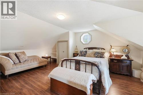 Room with sloped ceilings featuring wood-finish flooring, an octagonal window, and a built-in closet with shelving - 153 Montrose Street N, Cambridge, ON - Indoor Photo Showing Bedroom