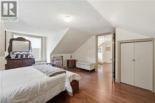 Sloped ceilings with a textured finish, wood-finish flooring, and a window with roller shade - 153 Montrose Street N, Cambridge, ON - Indoor Photo Showing Bedroom
