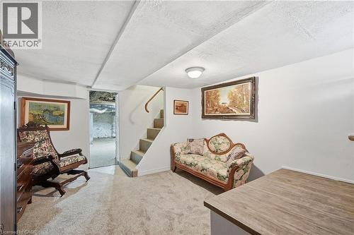 Finished lower level space featuring carpeted flooring and a built-in staircase with a wooden handrail - 153 Montrose Street N, Cambridge, ON - Indoor