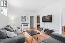 Living area featuring wood-finish flooring, white walls, and a recessed window - 