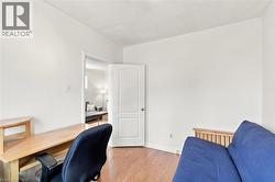 Interior room featuring wood-finish flooring and white painted walls - 
