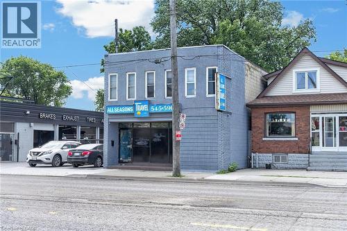 Two-story commercial building featuring a painted brick facade and a ground-level storefront with large display windows - 1292 Barton Street E, Hamilton, ON 