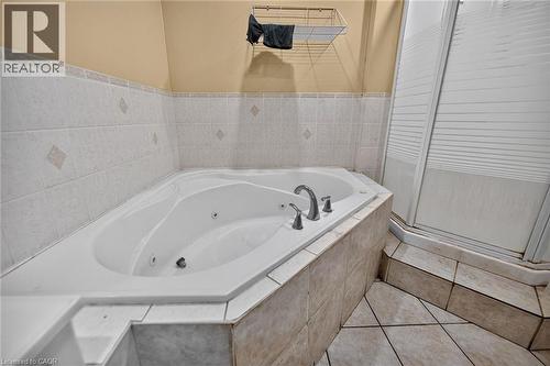 Soaking tub featuring integrated jets and deck-mounted chrome fixtures - 1292 Barton Street E, Hamilton, ON 