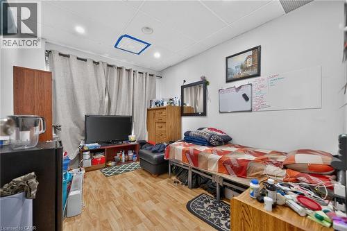Room featuring wood-finish flooring, white walls, and a drop ceiling with recessed lighting - 1292 Barton Street E, Hamilton, ON 