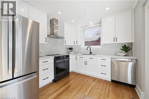 Modern kitchen featuring white shaker cabinetry, stainless steel appliances, a black electric range, and a coordinating black faucet - 18 Ipswich Place, Hamilton, ON - Indoor Photo Showing Kitchen With Upgraded Kitchen