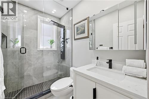 Bathroom featuring a glass-enclosed shower with gray tiled walls and hexagonal tile flooring - 18 Ipswich Place, Hamilton, ON - Indoor Photo Showing Bathroom