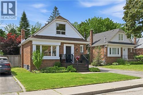 Brick exterior with white siding accents and a dormer window - 18 Ipswich Place, Hamilton, ON - Outdoor With Facade
