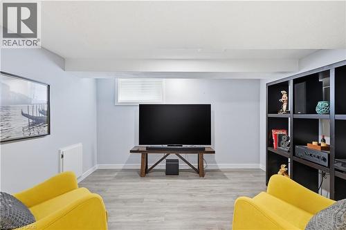 Finished lower level featuring light gray walls and wood-finish flooring - 18 Ipswich Place, Hamilton, ON - Indoor
