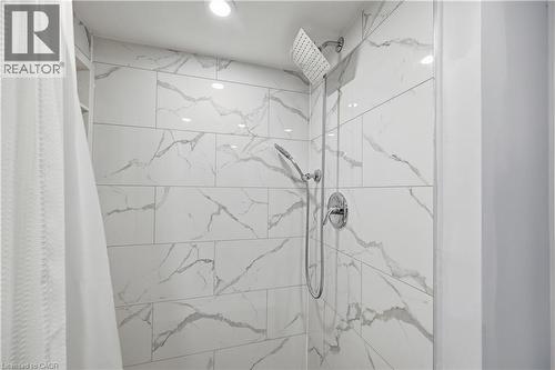 Shower with white veined tile surround, rain shower head, handheld shower fixture, and polished chrome hardware - 18 Ipswich Place, Hamilton, ON - Indoor Photo Showing Bathroom