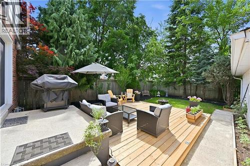 Expansive backyard featuring a multi-level deck, concrete patio, mature trees, and privacy fencing - 18 Ipswich Place, Hamilton, ON - Outdoor With Deck Patio Veranda