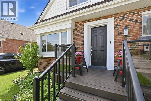 Brick exterior with white trim accents and a black paneled front door - 18 Ipswich Place, Hamilton, ON - Outdoor With Deck Patio Veranda With Exterior