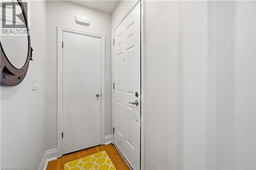 Entryway featuring wood-finish flooring, a white paneled door, and a built-in overhead light fixture - 18 Ipswich Place, Hamilton, ON - Indoor Photo Showing Other Room