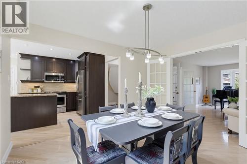 Dining area featuring light wood-finish flooring, a contemporary chandelier, and French doors - 2188 Bader Crescent, Burlington, ON - Indoor Photo Showing Dining Room
