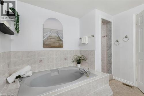 Built-in tub with tile surround and deck-mounted faucet - 2188 Bader Crescent, Burlington, ON - Indoor Photo Showing Bathroom