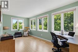 Spacious room featuring light green walls, and multiple large windows with white trim - 