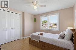 Bedroom featuring light a white bi-fold closet, and a ceiling fan with light fixture - 