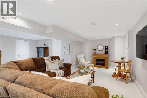 Spacious lower-level living area with recessed lighting, light-toned walls, and a built-in fireplace featuring a wood surround - 2188 Bader Crescent, Burlington, ON - Indoor Photo Showing Living Room With Fireplace