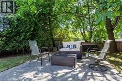 Paver patio with surrounding green space, mature trees, and privacy fencing - 