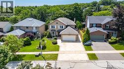 Traditional brick exterior featuring a multi-car driveway, attached garage, and landscaping - 