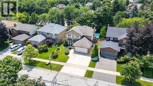 Traditional brick home featuring a two-car garage, mature landscaping, and an inground swimming pool - 2188 Bader Crescent, Burlington, ON - Outdoor