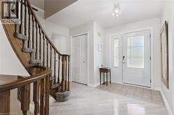 Gracious entryway featuring a curved wooden staircase with carpeted treads - 