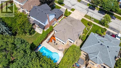 Aerial perspective showcasing a property with a swimming pool, spacious patio area, mature trees, and a well-maintained lawn - 2188 Bader Crescent, Burlington, ON - Outdoor With In Ground Pool With View
