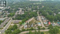 Aerial perspective showcasing a residential area with mature tree canopies, multiple streets, and varied property types - 