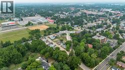 Aerial perspective showcasing a development site within a community featuring established residential areas, sports fields, and commercial structures - 