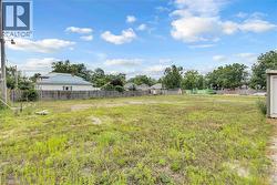 Expansive land parcel featuring existing perimeter fencing and mature trees along the property line - 