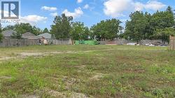 Expansive lot featuring a cleared, level terrain, partial fencing, and mature trees along the perimeter - 