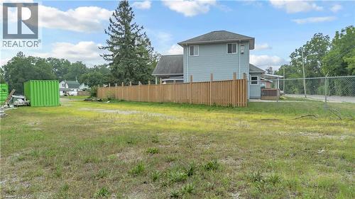 Spacious lot featuring a partial privacy fence, chain-link fencing, and mature trees on the perimeter - 9 James Street, Simcoe, ON 