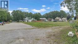 Expansive undeveloped lot featuring a partially graveled surface and a grassy area - 
