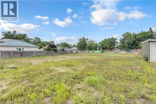 Expansive grassy lot featuring a perimeter fence and mature trees - 9 James Street, Simcoe, ON 