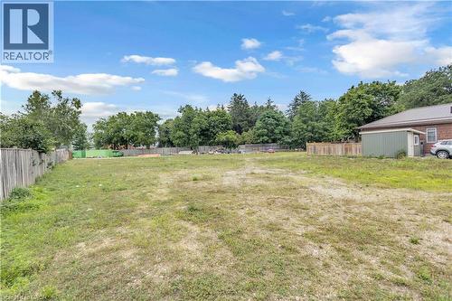 Spacious lot featuring perimeter fencing, mature trees, and a utility shed - 9 James Street, Simcoe, ON 