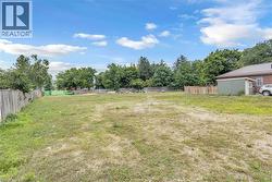 Spacious lot featuring perimeter fencing, mature trees, and a utility shed - 