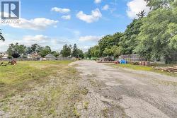 Expansive open lot featuring a combination of gravel and grassy areas - 