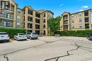 Multi-story residential building featuring balconies with black railings, a stone-clad turret, and light-colored stucco exterior - 2035 Appleby Line Unit# 307, Burlington, ON  - Outdoor With Balcony With Facade 