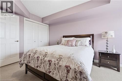 Lilac-painted walls with light beige carpeting, white panel doors, and recessed ceiling details - 2035 Appleby Line Unit# 307, Burlington, ON - Indoor Photo Showing Bedroom