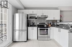 Modern kitchen featuring white cabinetry, stainless steel appliances, a textured metallic backsplash, and granite-style countertops - 