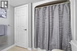 Shower-tub combination featuring a curved shower rod and a light gray patterned shower curtain - 