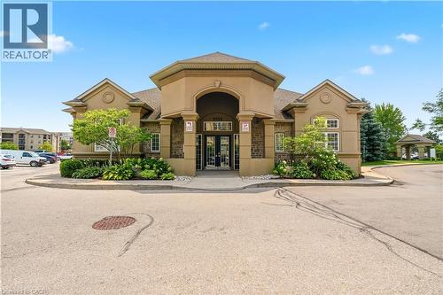 Stucco and stone facade building with a prominent arched entry and double glass doors - 2035 Appleby Line Unit# 307, Burlington, ON - Outdoor