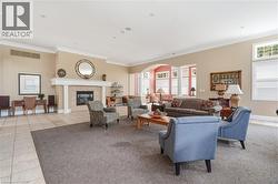 Spacious common area featuring a central fireplace with mantle, tile flooring, and broad archways - 