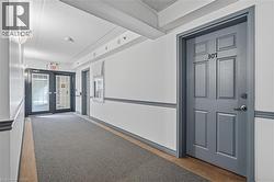 Common hallway with gray carpet runner and white walls featuring gray wainscoting - 