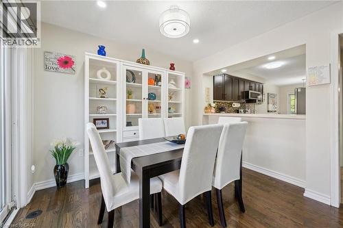 Dining area featuring wood-finish flooring, a white built-in display cabinet, and recessed lighting - 36 Van Fleet Terrace, Milton, ON - Indoor Photo Showing Dining Room