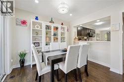 Dining area featuring wood-finish flooring, a white built-in display cabinet, and recessed lighting - 