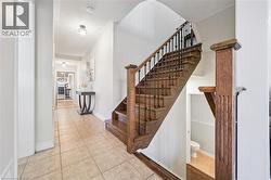 Wood-finish staircase with black iron spindles and a substantial newel post - 