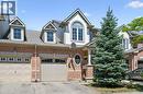 Brick and siding exterior featuring gabled dormers, an arched window, and a prominent evergreen tree - 36 Van Fleet Terrace, Milton, ON  - Outdoor 